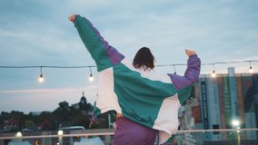 Joyful caucasian girl in sports outfit wearing headphones dancing into music under street lights evening illumination. Hip-hop queen. Breakdancer woman. Holiday decoration. - Powered by Shutterstock - Get 15% off with code: PIKWIZARD15