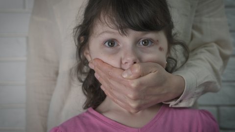 Child abuse. The child is covered with a mouth.