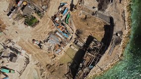 Video from the drone of the construction of a wooden boat on a sandy pier by the sea with blue water