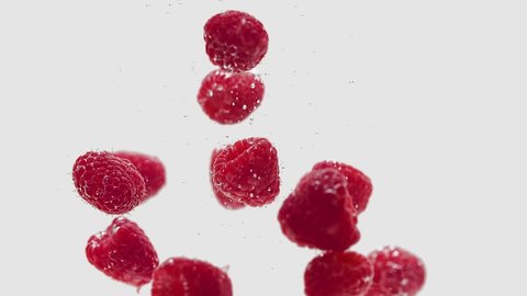Fresh Raspberries Falling Into Water, Isolated on White Background