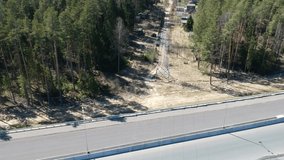 Road construction work. Shooting from the air on a drone toll road with a new asphalt coating. The track in the woods. Video of process of building the highway. Panoramic High quality FullHD footage
