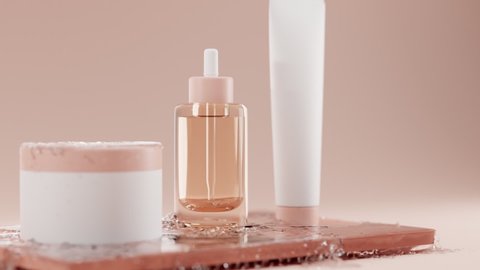 Skin care for face and body. 3D set of transparent glass bottle with dropper for liquid products and white blank cosmetic plastic cans on brown glossy dish in an icy water spray on beige background