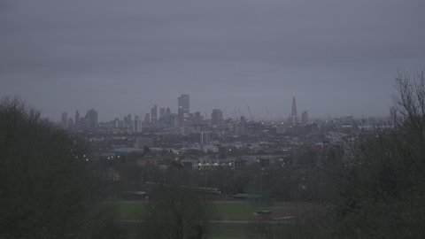 London iconic skyline from Parliament Hill Hampstead Heath with passing train under brooding sky
