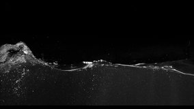 Small waves flowing from the left side to the side over a black background from the Submerge collection - Water VFX Video Element.