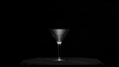 Effect of a martini glass shattering slowly from a gun shot over a black background from the Fragment collection - Glass VFX Video Element.