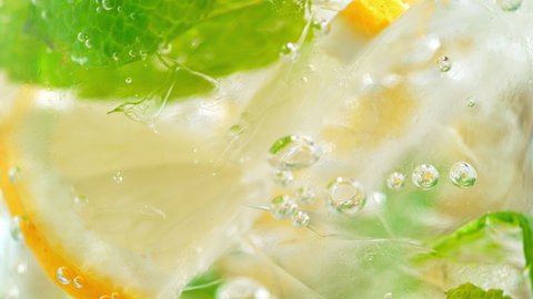 Macro Shot of Fizzy Soft Drink with Ice, Bubbles, Mint and Lemon. Phantom Flex 1000fps