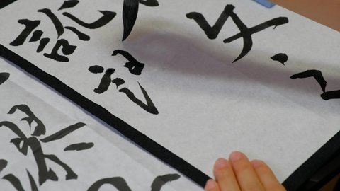A Japanese woman practicing calligraphy
What the woman is writing about is part of a Chinese history book