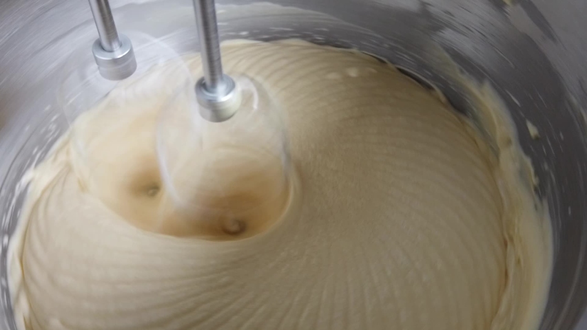 Chef is mixing ingredients with electric mixer in bowl. Preparing delicious cream to make cake. Out of focus.  Royalty-Free Stock Footage #1059950405