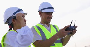 Asian Drone Operator Inspecting Construction Building With Drone