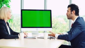 Business people in the conference room with green screen chroma key TV or computer on the office table. Diverse group of businessman and businesswoman in meeting on video conference call.