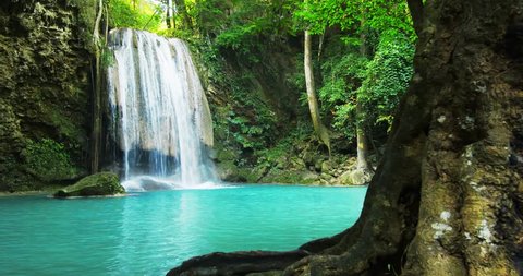 Paradise jungle forest with beautiful waterfall in green lush of Erawan park in Kanchanaburi, Thailand. Emerald pond and exotic plants