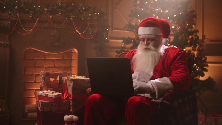 Santa Claus warm atmosphere in living room using laptop. | Shutterstock HD Video #1059957293