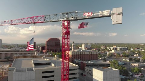 Colorado Springs , Colorado / United States - 09 13 2020: Stars and Stripes USA flag flutters below huge red construction crane