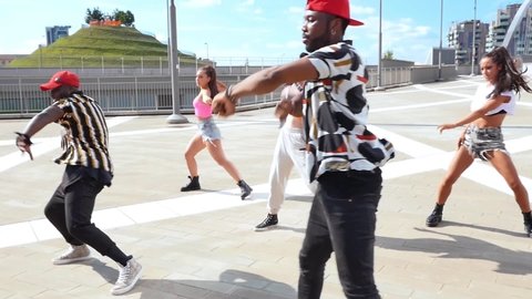 Group of urban dancers performing outdoor. Multi-ethnic hip hop crew dancing and having fun