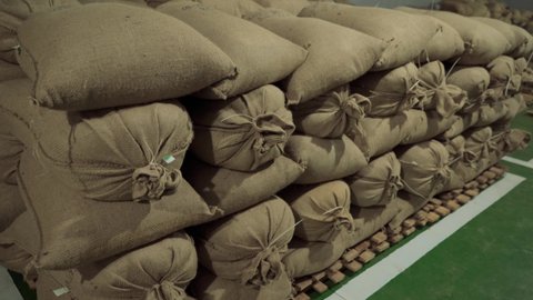 Bags of coffee in warehouse. Stock burlap sacks full of coffee.