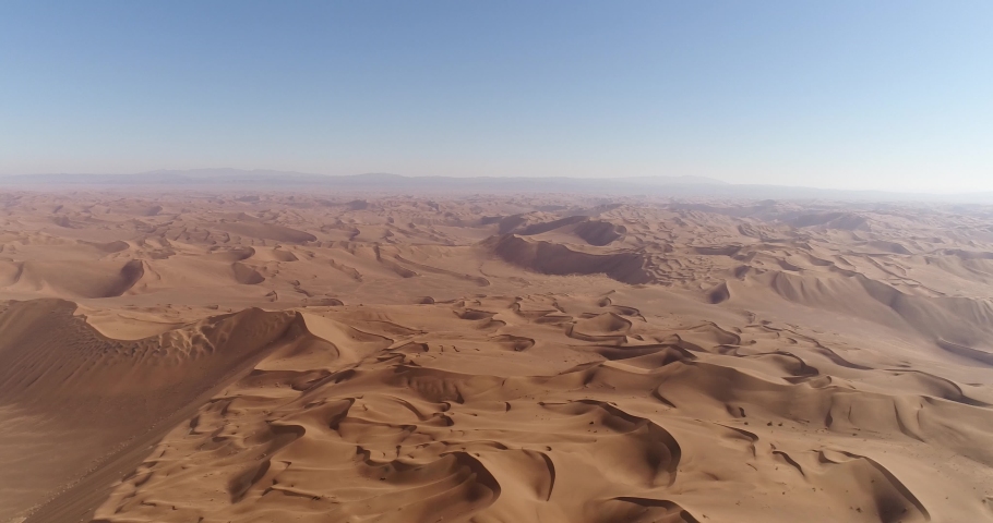 High attitude pan to left aerial shot from the formation of sand dunes in dasht e lut or sahara desert, aerial shot from sand dunes | Shutterstock HD Video #1059975962