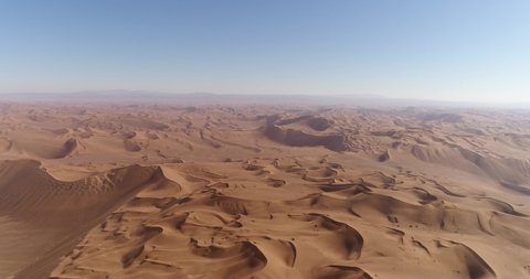 high attitude pan to left aerial shot from the formation of sand dunes in dasht e lut or sahara desert, aerial shot from sand dunes