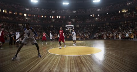 Basketball player scores a goal on a professional basketball stadium. Stadium is made in 3d with animated crowd. Dynamic shot.