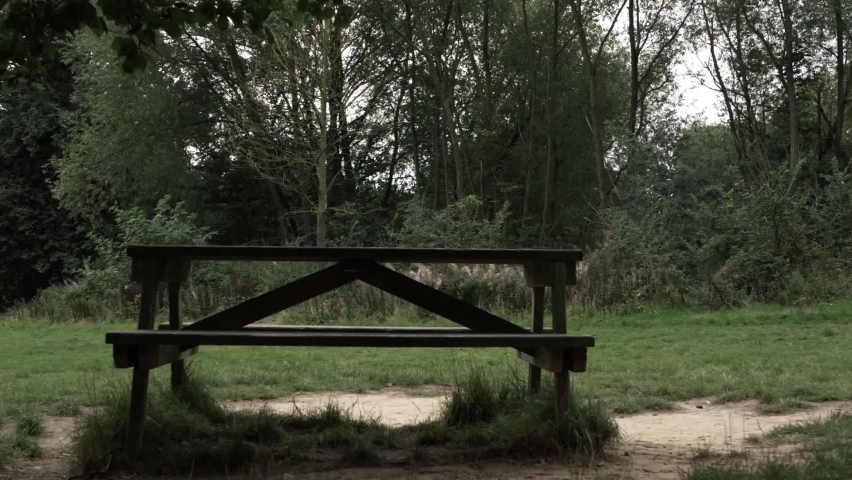 Picnic bench in countryside park wide panning shot