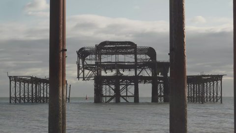 famous burnt pier in brighton city england uk. columns on the beach and calm sea