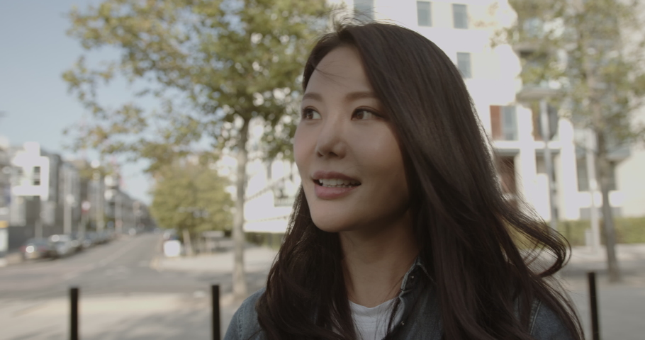 Beautiful Asian woman looking into camera, Portrait Korean female in City | Shutterstock HD Video #1059983024