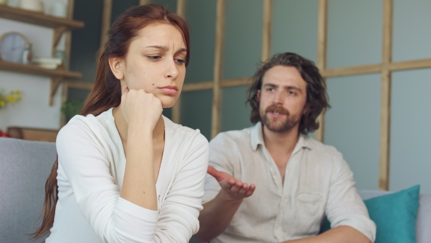 Couple Quarreling Sitting on the Couch at Home, Boyfriend Screams Accusing Girlfriend. Relationship Problems by Reason of Disagreement. The Man and Woman are Arguing. Young Woman Feeling Lonely. Royalty-Free Stock Footage #1059984638
