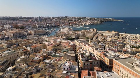 Drone flies above the sicilian island Ortygia (Ortigia) and harbor with boats and yachts in province of Siracusa (Syracuse) in Sicily