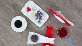 Top view spinning video of coffee cup with cookies and flowers.
