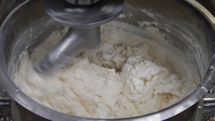 Preparation of dough in production with a professional dough mixer. Industrial mixer for kneading dough Royalty-Free Stock Footage #1059994622