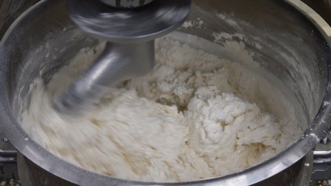 Preparation of dough in production with a professional dough mixer. Industrial mixer for kneading dough