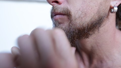 Man touches his beard on white background