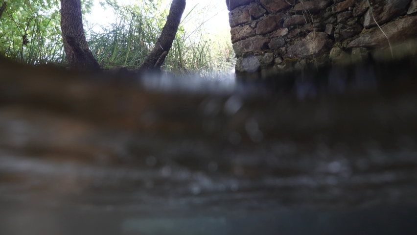 split shot  of a little waterfall underwater carrying alluvium in freshwater river in nature