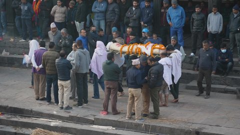 Pashupatinath, Kathmandu, Nepal. 12-15-2019. Body being taken to be cremated and people looking at Pashupatinath temple ghats .