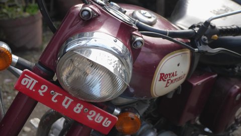 Pokhara, Nepal. 1/1/2020. Slow motion pan high angle shot of red Royal Enfield Classic 500 head lamp, logo and seat.