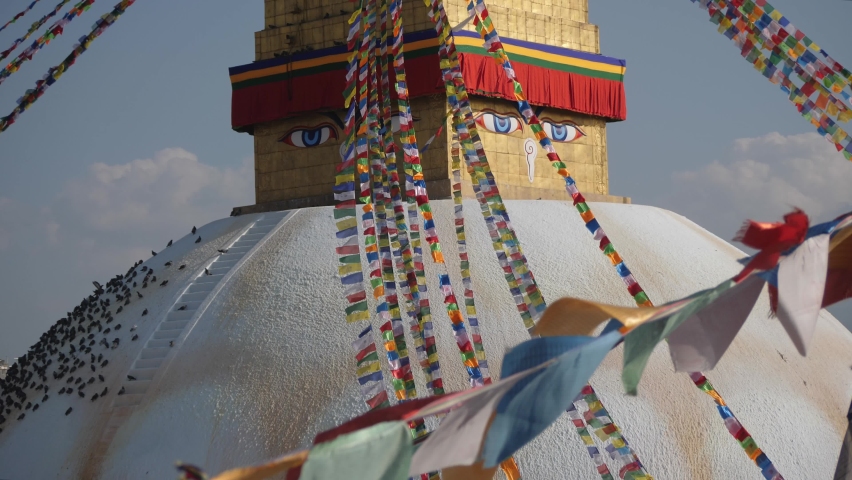 Bouddha, Nepal. Buddhas eyes and buddhist prayer flags at Bouddha stupa. | Shutterstock HD Video #1060009385