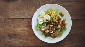 Eating a Grilled Chicken Cobb Salad On a Wooden Background