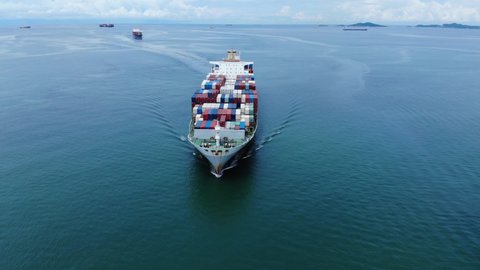 Aerial view of cargo ship carrying container and running with tug boat for export  goods  on clam sea from  cargo yard port to custom ocean concept freight shipping by ship .