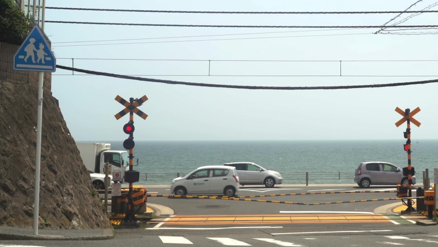 Railroad crossings overlooking the sea and passing trains Royalty-Free Stock Footage #1060015970