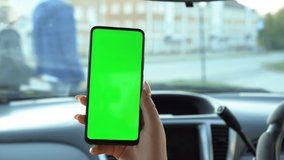 Close up of a woman's hand holding a mobile telephone with a vertical green screen in car chroma key smartphone technology cell phone street touch message display hand