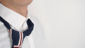 Asian business in formal dress adjusting fashionable knit neck tie on white background. - Powered by Shutterstock - Get 15% off with code: PIKWIZARD15