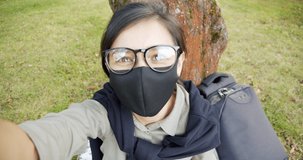 Young woman in protective mask making selfie during walking in park, video chat conference with friends, tourist after covid. Lifestyle during covid-19, quarantine.