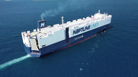 Piraeus port, Attica / Greece - September 27 2020: Aerial drone video of Neptune lines huge car carrier ship RO-RO (Roll on Roll off) cruising near port of Piraeus