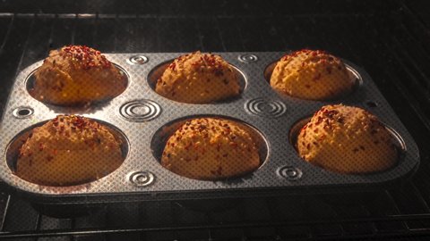 homemade delicious sweet muffins baking in oven close-up. time lapse with growing cupcakes and sesames in oven