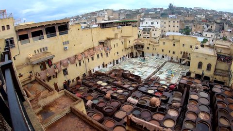 Panorama of Moroccan workers at Fez tanneries proccesing leather view from top terrace with a wide angle