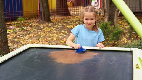 Girl playing air hockey in the Park. outdoor games and entertainment in parks. 