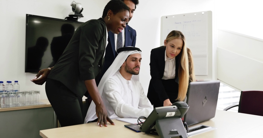 Mixed business team in Dubai. Business meeting with men wearing kandura and western people in the office