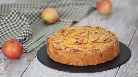Cutting a piece of delicious apple cake with a knife.