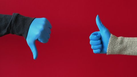 Pandemic conflict. Quarantine pros and cons. COVID-19 outbreak hygiene measures. Hands in blue protective gloves showing opposite approval disagreement gestures isolated on red background loop.