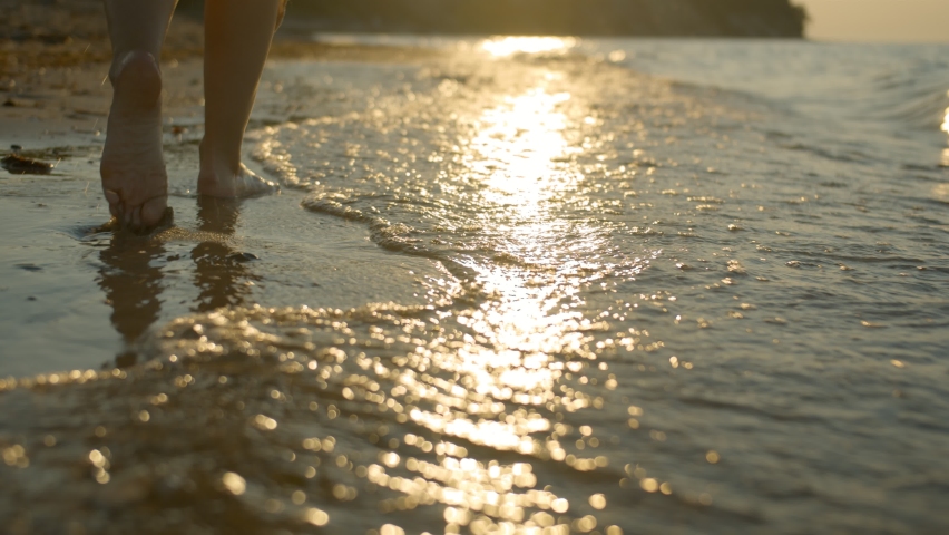 Walking feet on the coast with a beautiful sunset Royalty-Free Stock Footage #1060057688