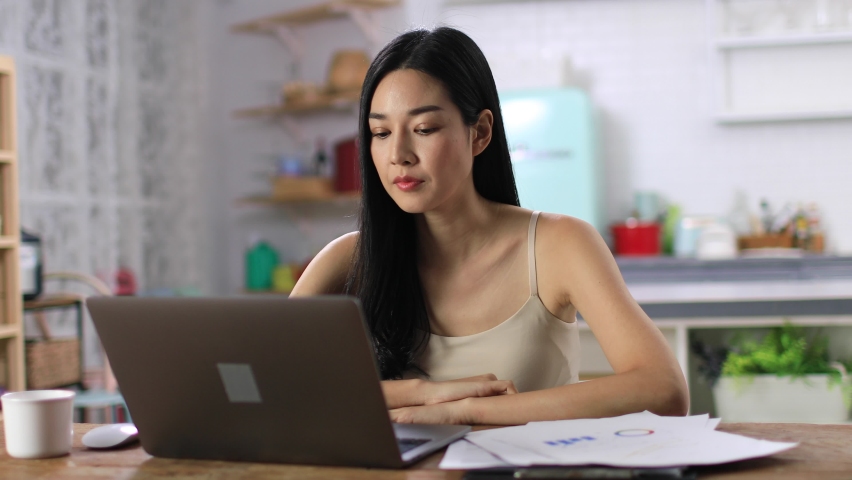 Stressed asian woman working at home. young overworked woman feeling tired and sleepy. Female worker feel fatigue and closing her eyes while working on laptop. Concept of overwork. | Shutterstock HD Video #1060059029